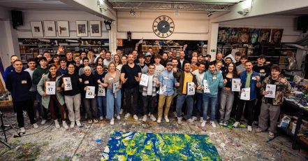 Vorbereitungsevent zu "The Colourful Art of Football". Der Künstler Christian Nienhaus (erste Reihe, Bild-Mitte, schwarzes T-Shirt) mit allen Freiwilligen, die am 5.5. an dem Fußball-Kunstwerk und dem Rekordversuch, das "größte Bild der Welt" zu erstellen, beteiligt sein werden. (Bildrechte: Christian Nienhaus / TAS Emotional Marketing)