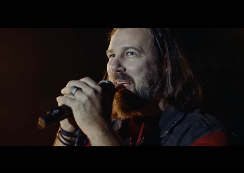 Bild: Happy Bärsday – 100 Jahre Haribo Goldbären – Screenshot aus dem HARIBO Jubiläums-TVC im Stil der beliebten Kid's Voices Werbespots. Erwachsene "Rocker" singen den Goldbären mit Kinderstimmen ein Geburtstags-Ständchen. (Quelle: www.haribo.com/geburtstag)