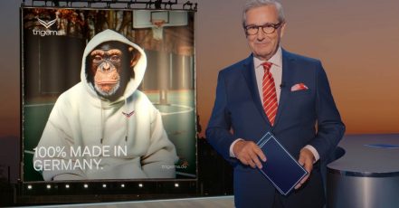 Jan Hofer verkündet im TV die Rückkehr von Affe Charly für TRIGEMA – Charly übernimmt als KI-Fashion-Influencer die Social Media Kanäle des deutschen Bekleidungsherstellers. (Bildquelle: TRIGEMA / thjnk)