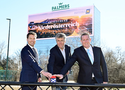 Bild: Startschuss für die riesige LED-Wall 'Number One' am Palmers-Hochhaus: Ralph Hofmann (Palmers), Martin Schuster (NÖ Landtag) und Michael Müllner-Baatz (Number One) begleiten die Inbetriebnahme. Bildrechte: leisure communications/Christian Jobst.