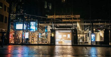 Außenansicht des neuen Porsche Brand Experience Stores mit dem Motto "Driven by Dreams"
