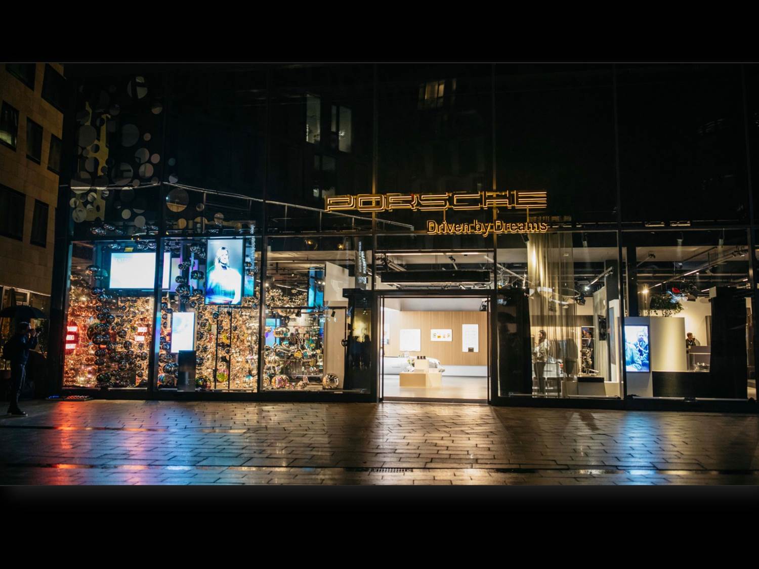 Außenansicht des neuen Porsche Brand Experience Stores mit dem Motto "Driven by Dreams"