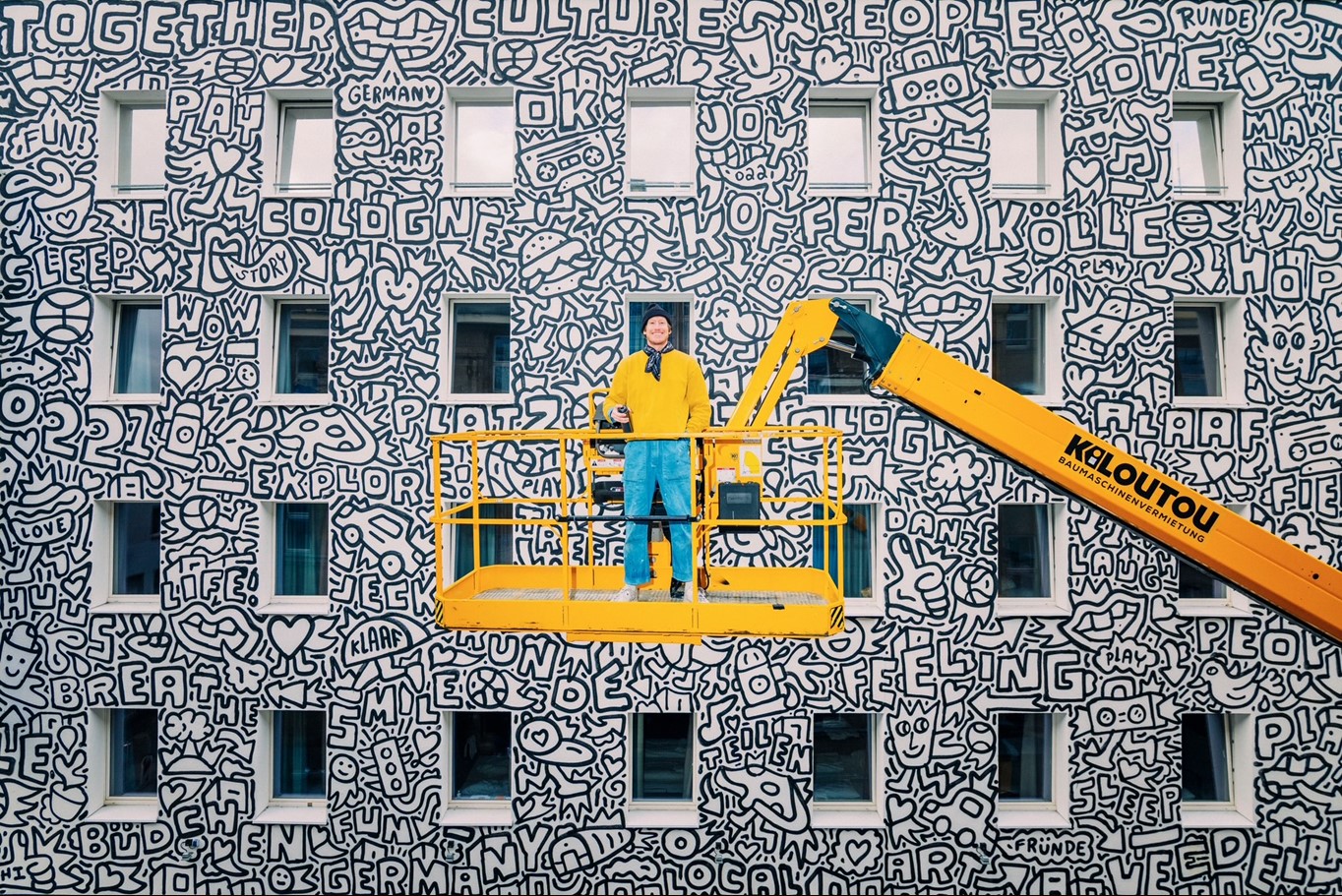 Der New Yorker Künstler Timothy Goodman vor dem von ihm gestalteten Mural für a&o Hostels, Köln Neumarkt (Foto: Felix Kleymann)