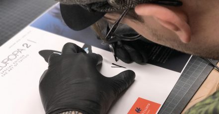 Künstler Tobi Tietchen signiert Katalog-Cover mit Tattoo-Nadel